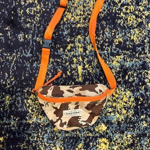 tan eastpak camo crossbody w orange strap